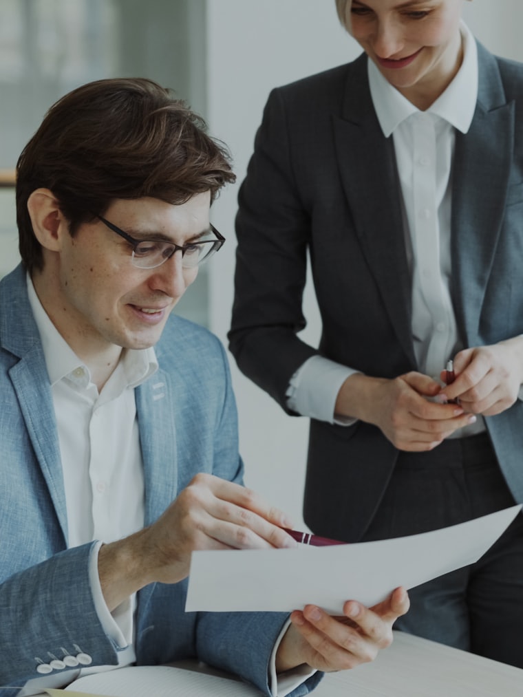 Dos profesionales de finanzas revisando un documento en una oficina corporativa